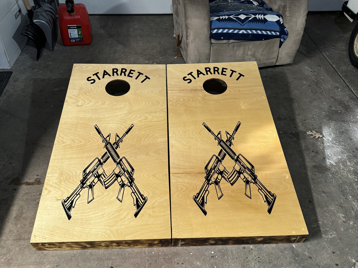 Custom cornhole boards with a company logo and crossed rifles design
