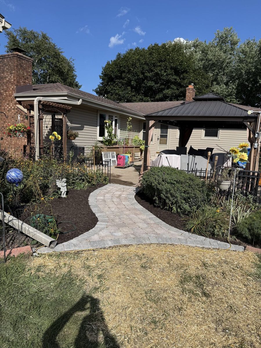 Finished paver walkway curving toward the patio and gazebo