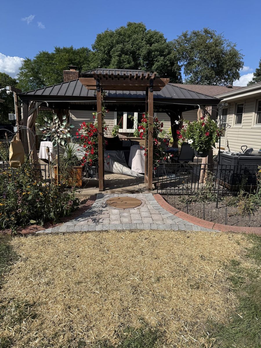 Paver walkway and lawn leading up to the gazebo and arbor