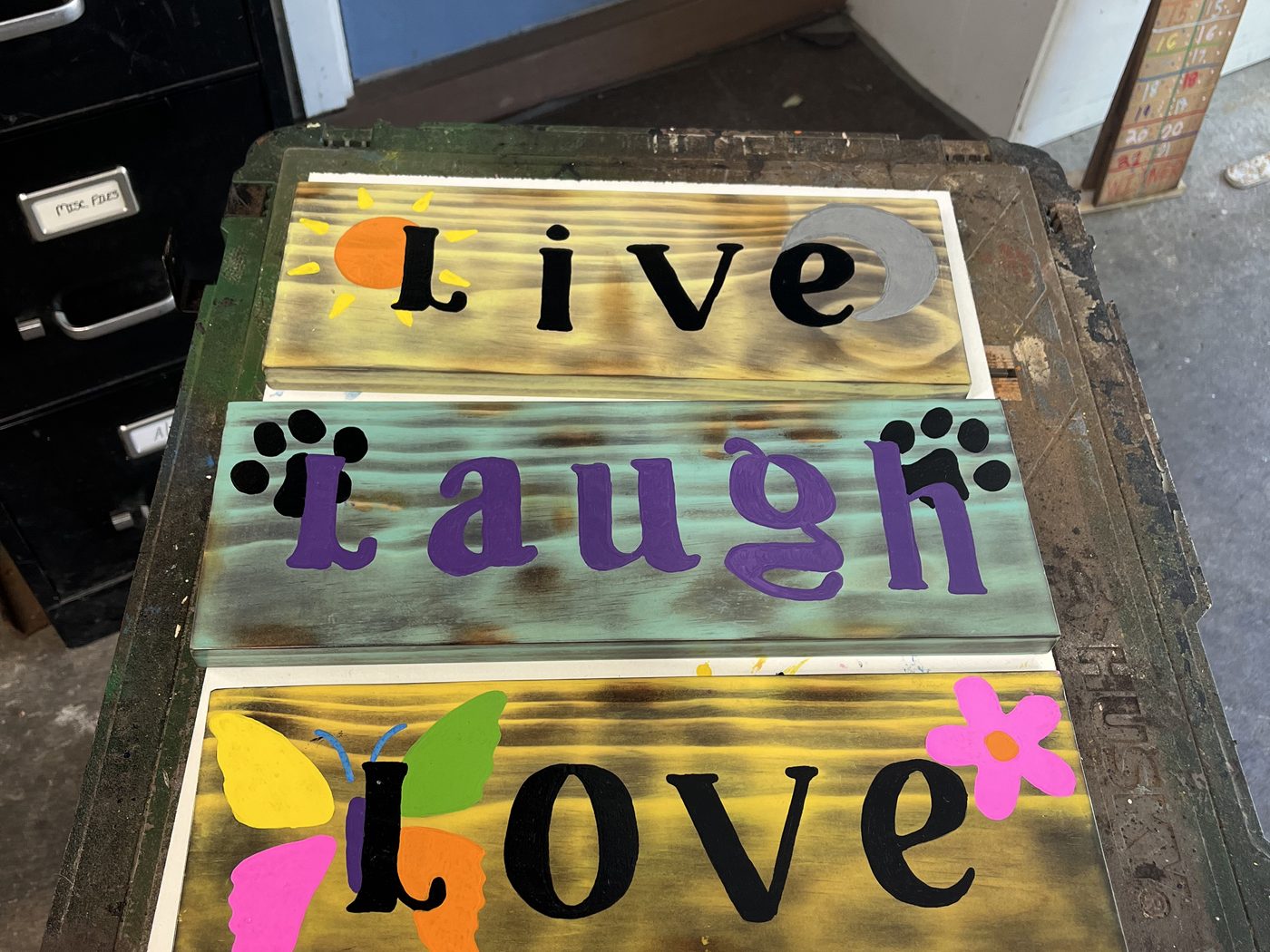 Custom wood sign reading Live Laugh Love with painted flowers and paw prints
